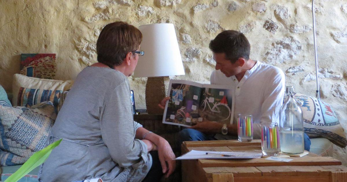 One-to-one French lesson: the teacher goes through a magazine with a student, using an authentic document